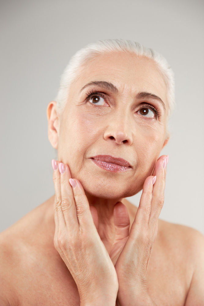 Happy grey-haired woman looking up – Experience the benefits of stem cell anti-aging treatments for natural skin rejuvenation.